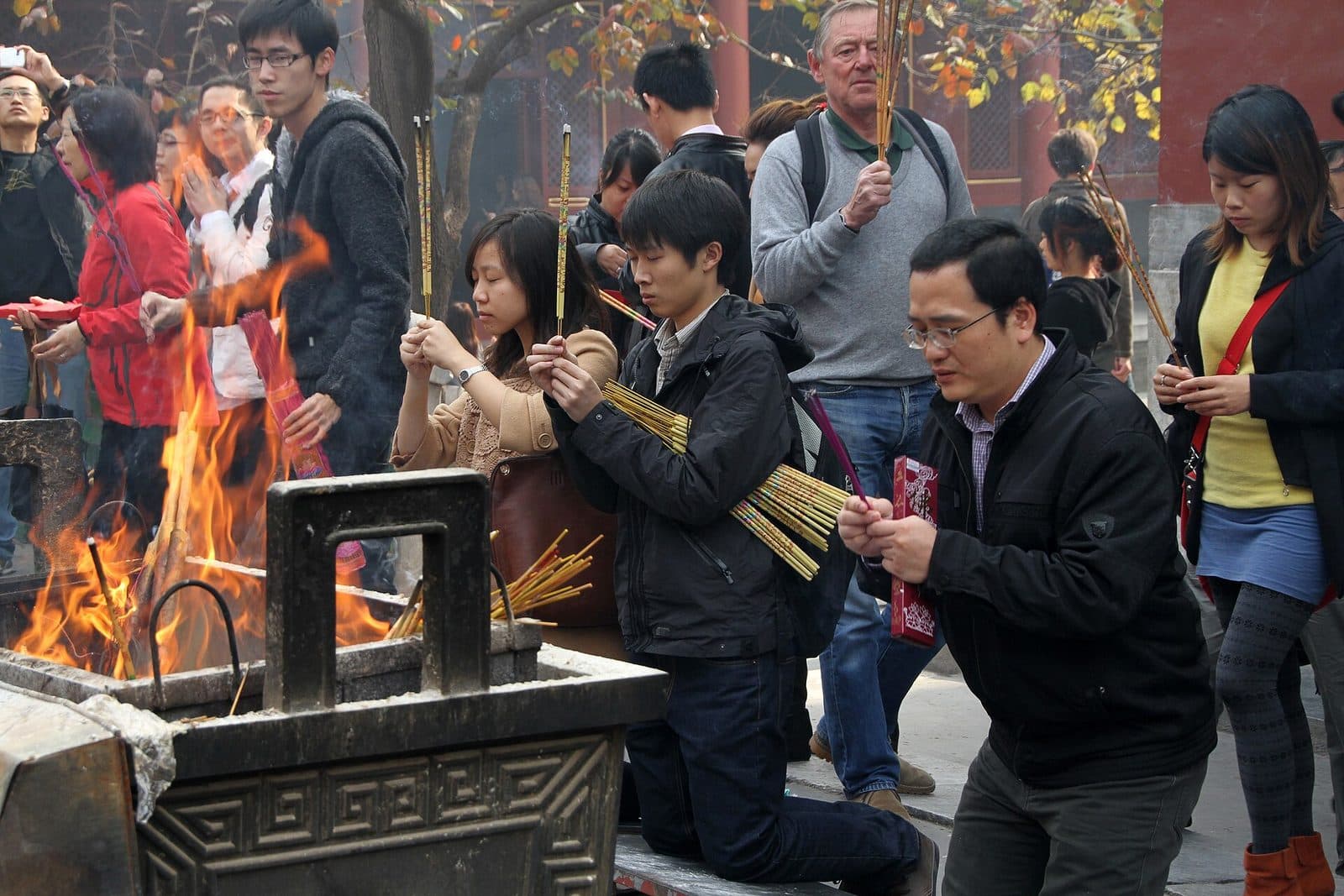 Visitors offering incense in a courtyard at Yonghe Lama Temple Beijing