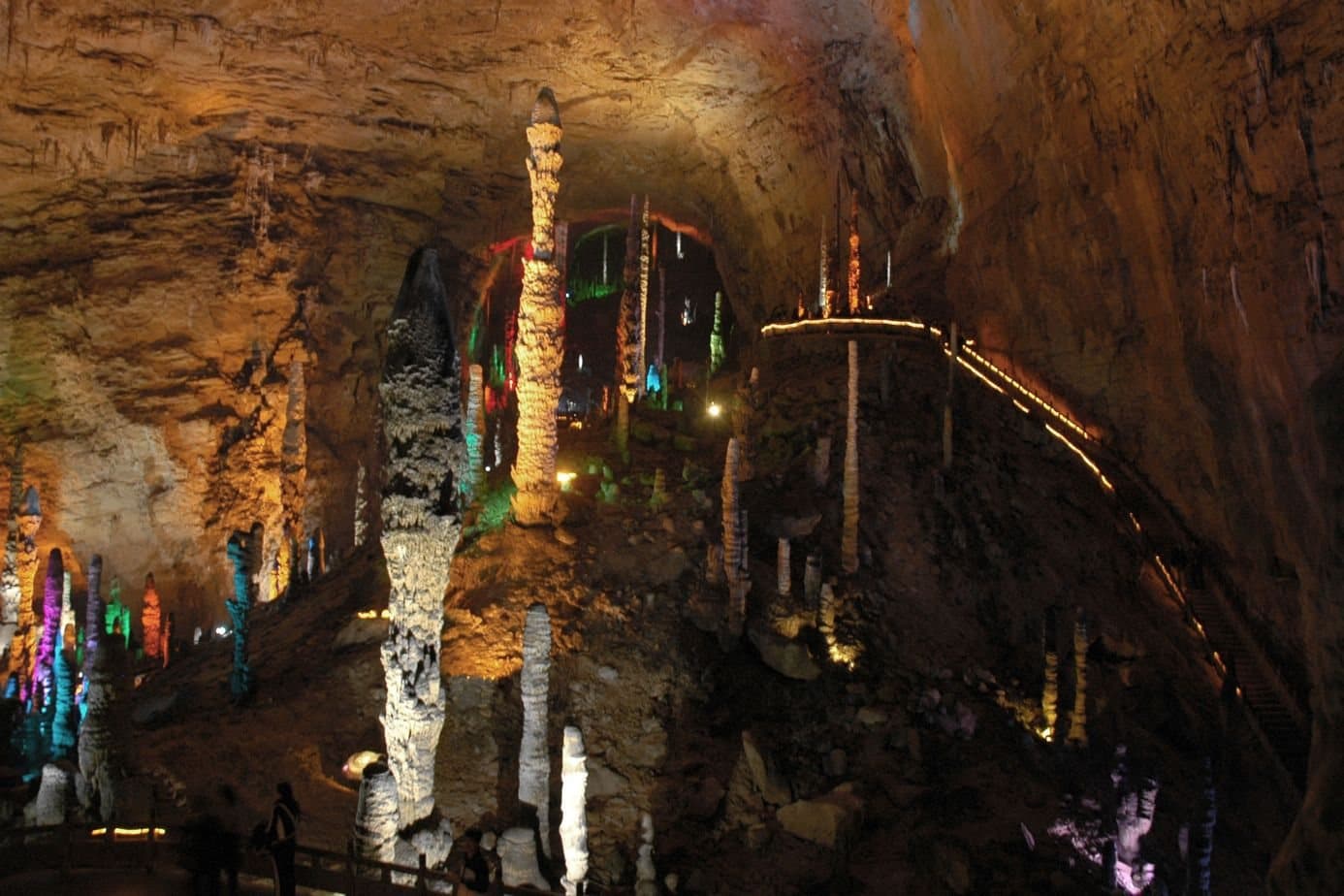 Illuminated karst formations inside Huanglong Cave — view 1