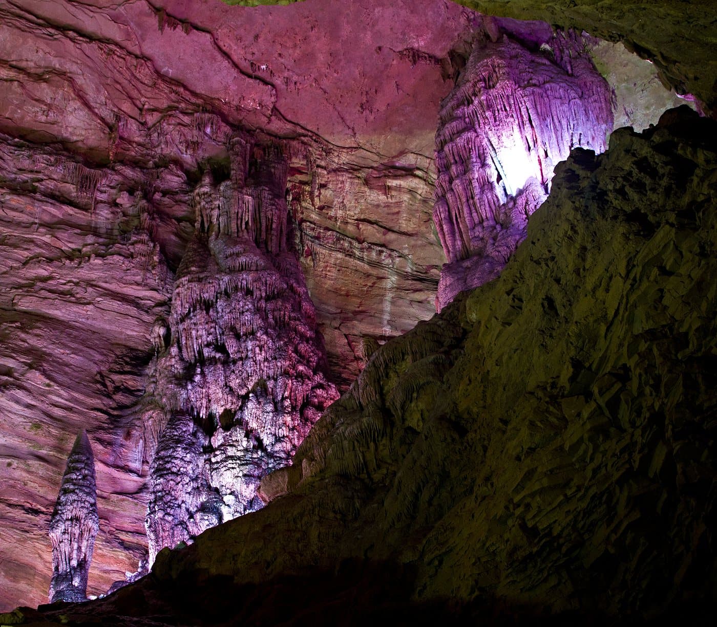 Illuminated karst formations inside Huanglong Cave — view 2
