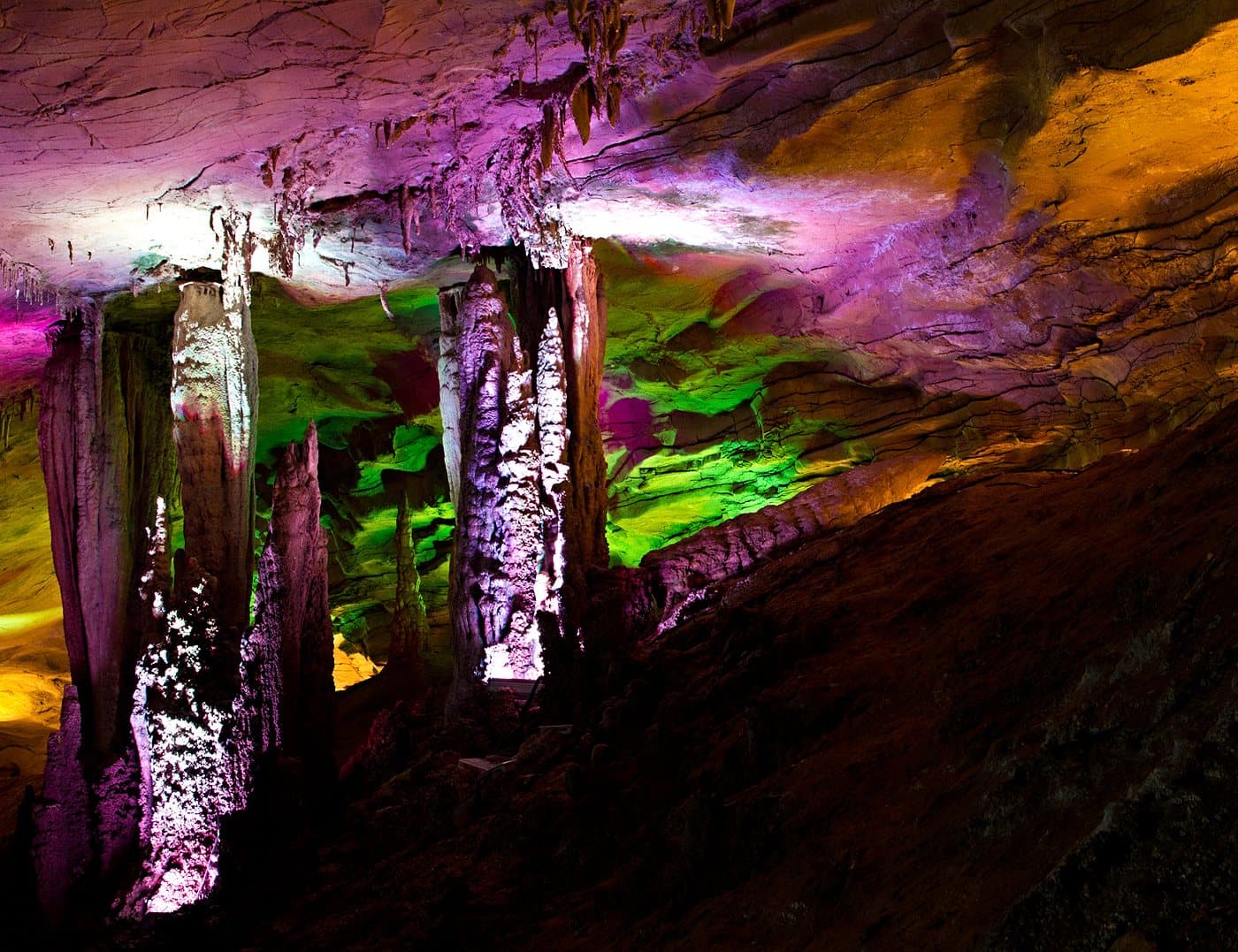 Illuminated karst formations inside Huanglong Cave — view 3